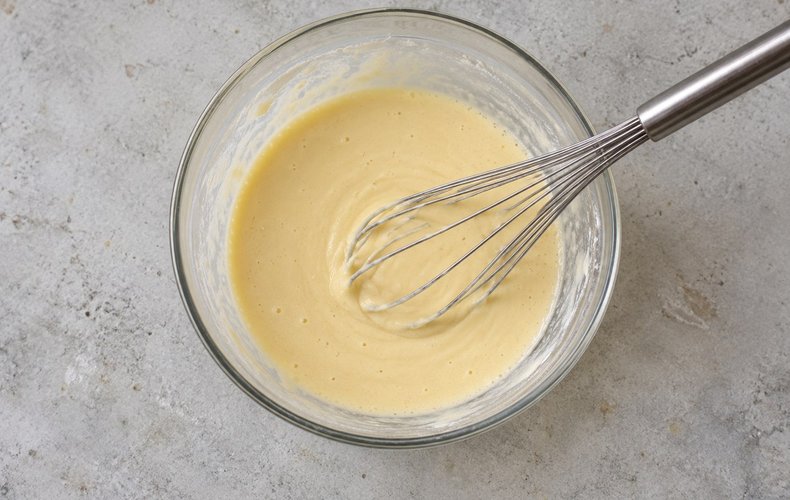 Crêpeteig mit dem Schneebesen in der Schüssel verrühren