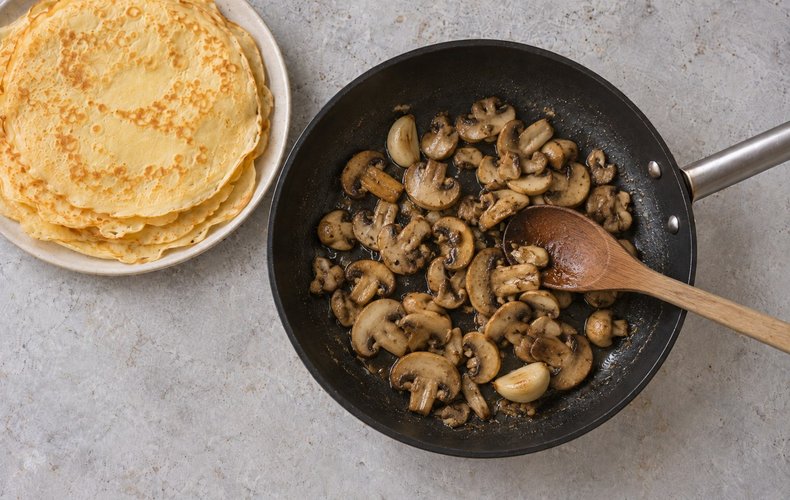 Pilze mit Knoblauch und Petersilie in der Pfanne