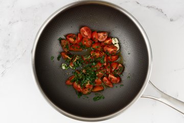 Kirschtomaten mit Knoblauch, Chili und Petersilie in der Pfanne